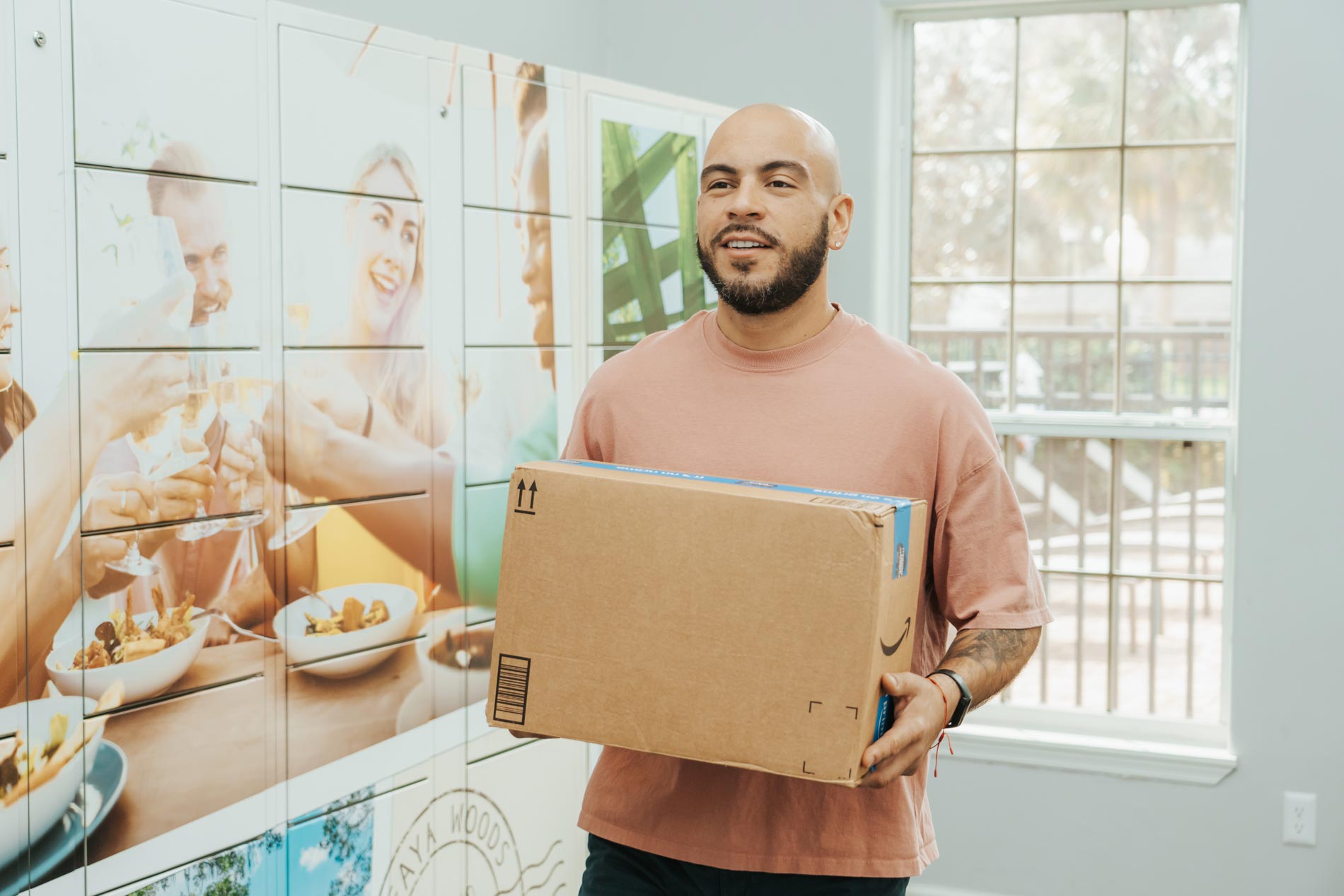 alafaya woods man carries package from mail room