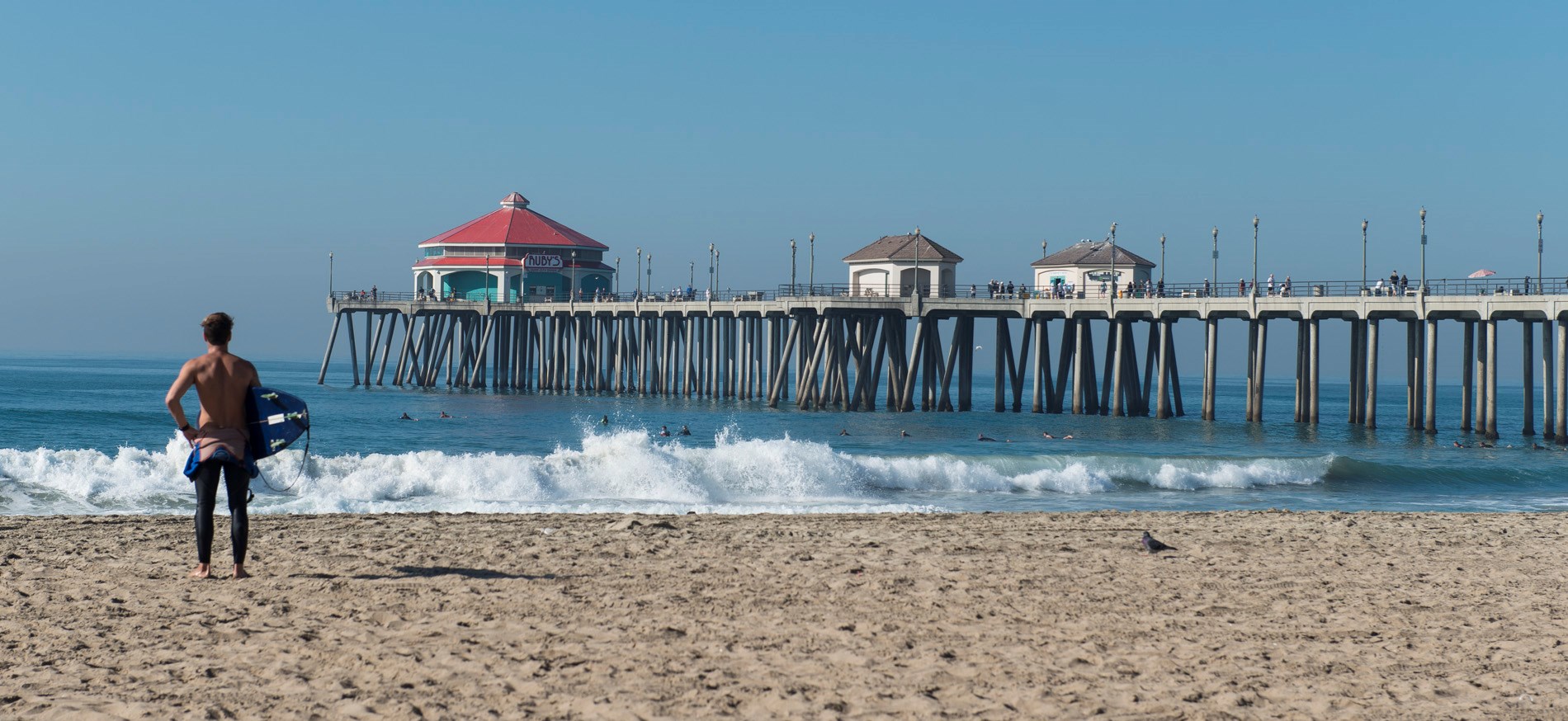 Man stands by the beach pier