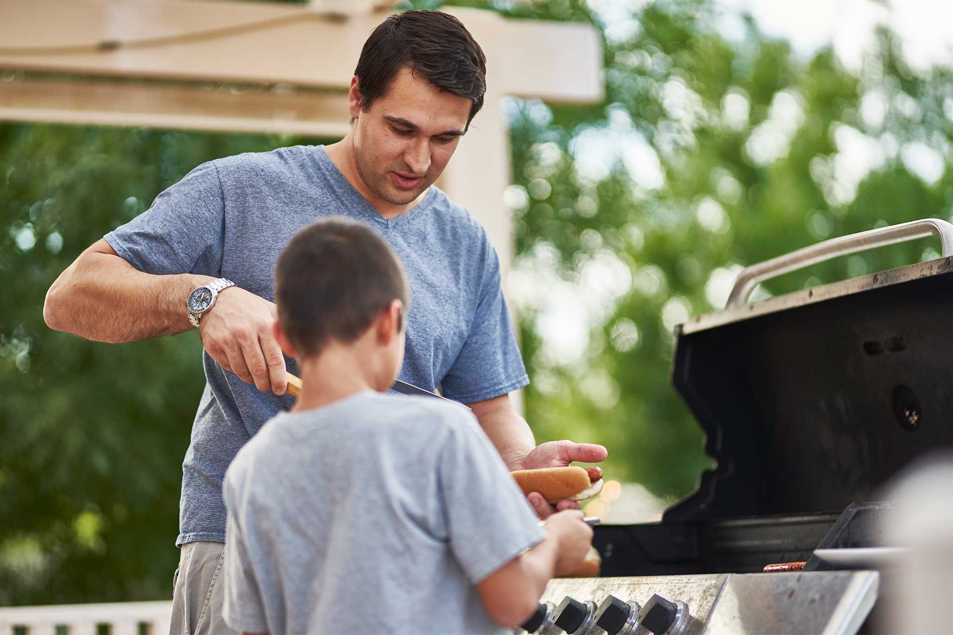 Man and young child at grill