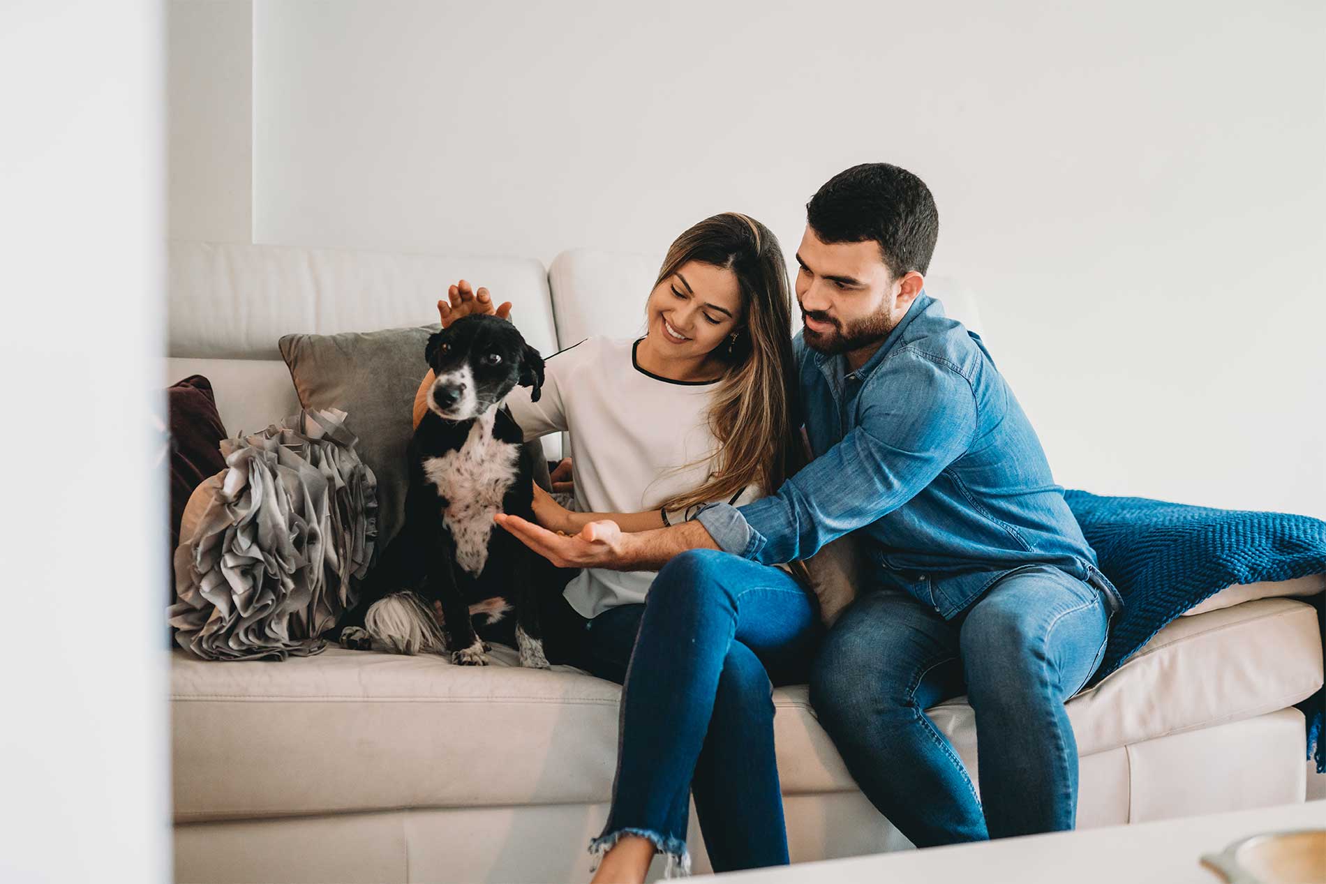 Man and woman sitting on couch with dog