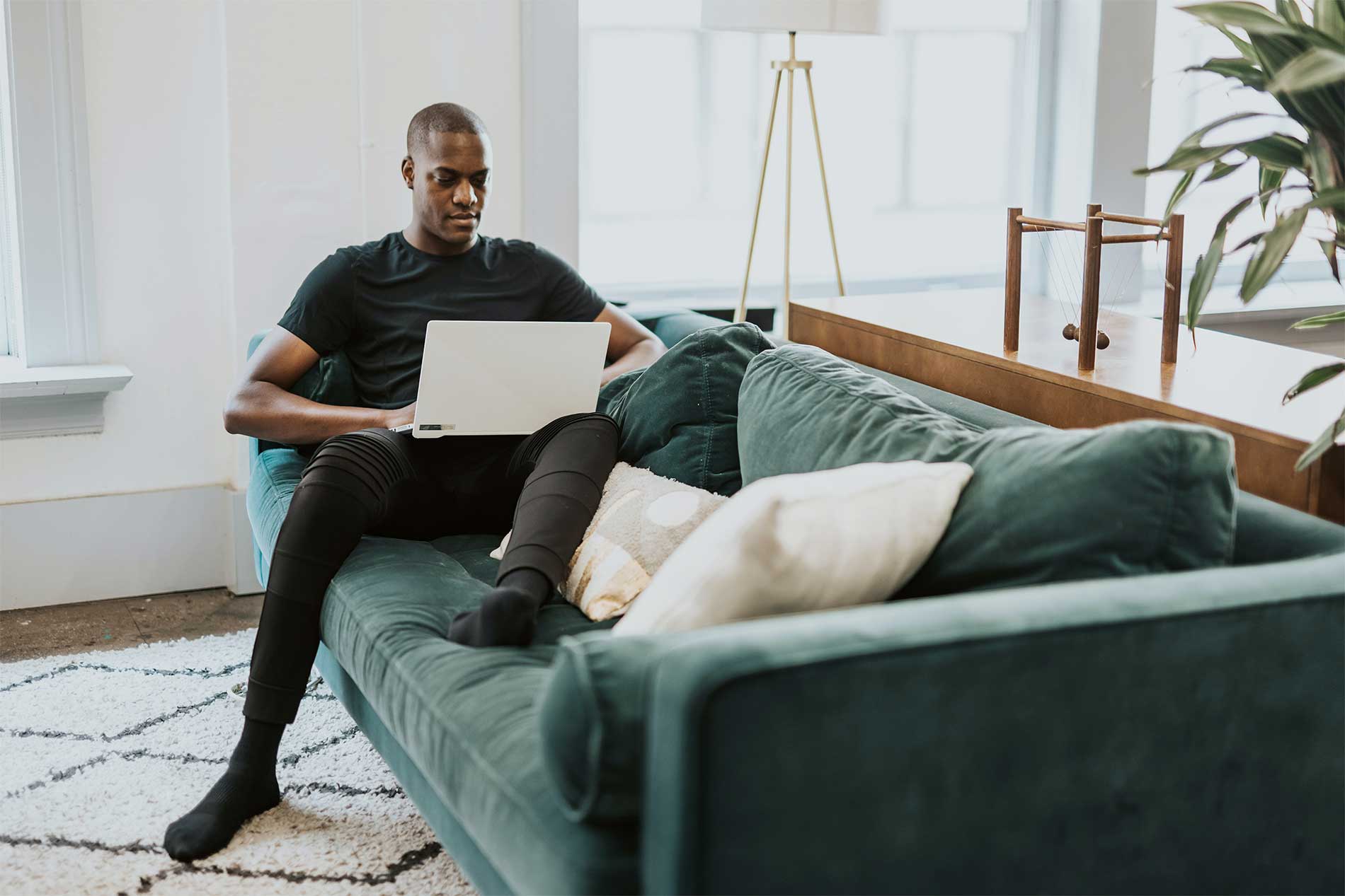 Man lounging on couch while on laptop