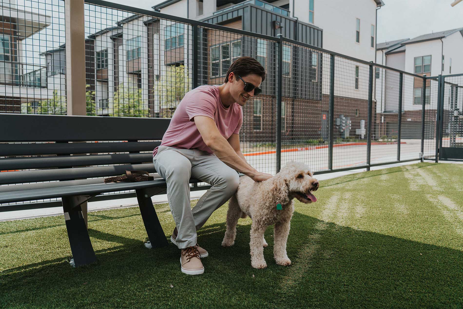 Young man with happy dog in dog park