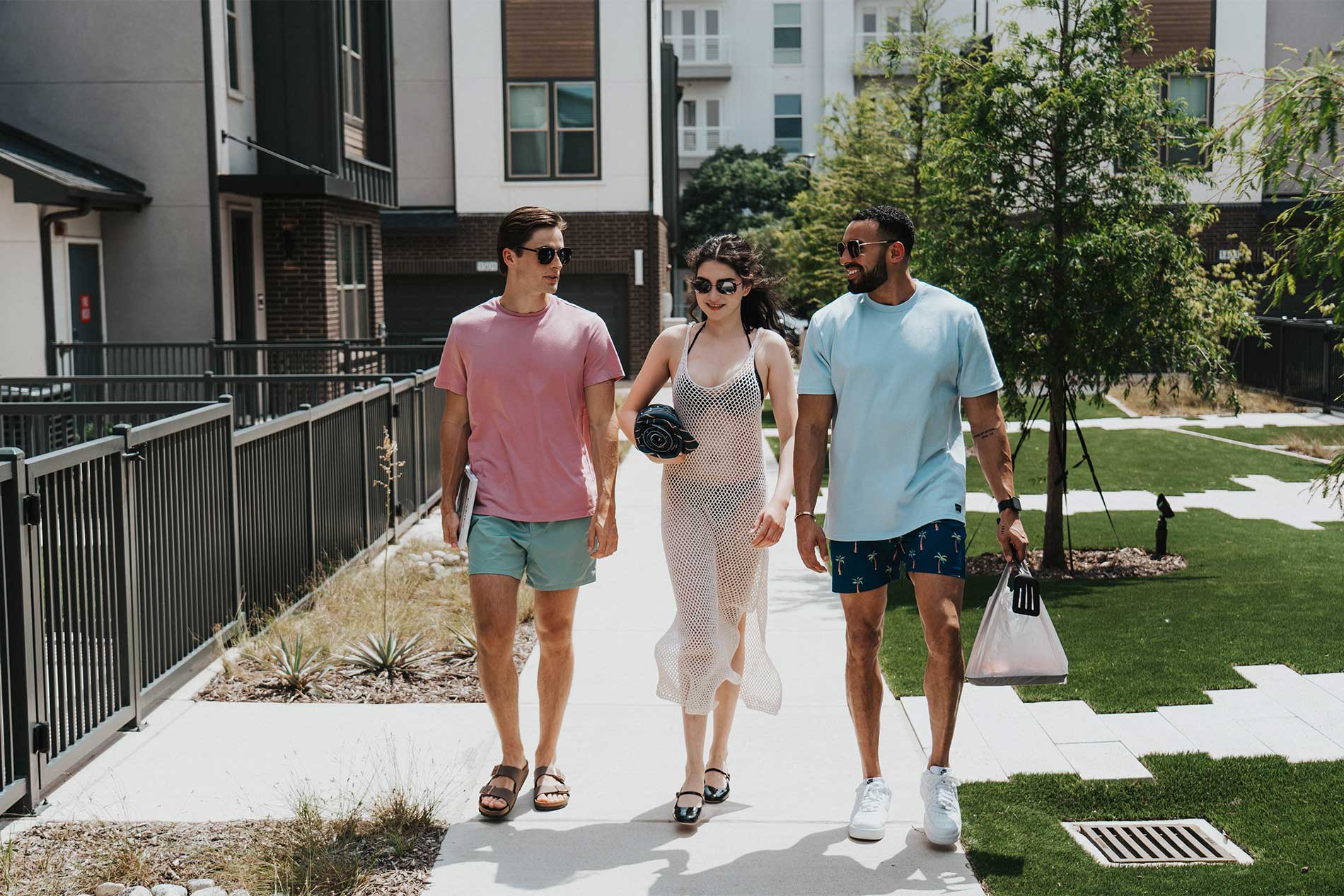 Three young people walking to the apartment swimming pool